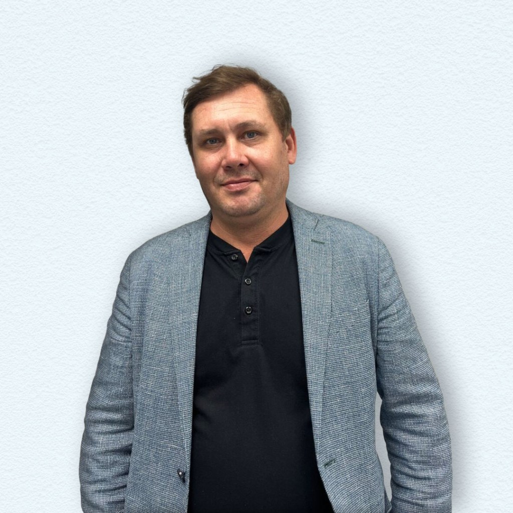 a man standing in front of a white wall