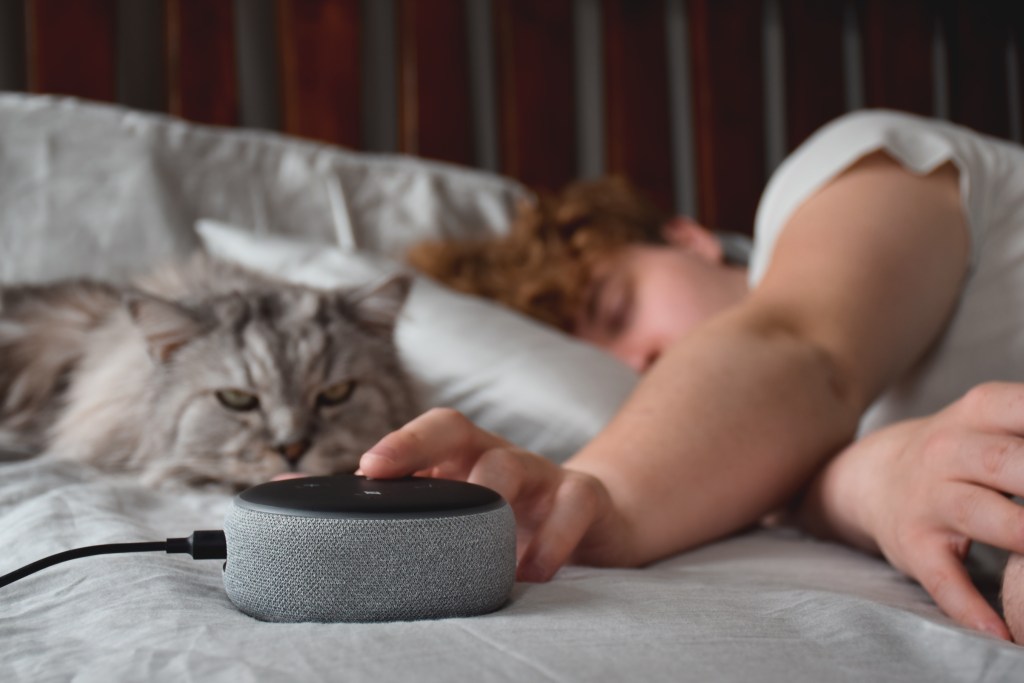 Assistive technology month 2023: a woman laying in bed next to a cat