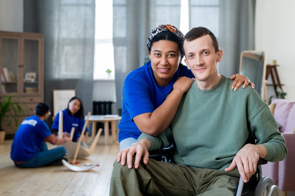 a man in a wheel chair hugging a woman