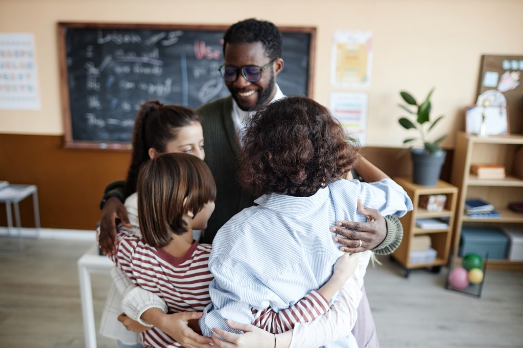 a group of people hugging each other in a room